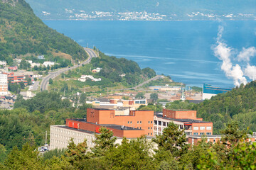 An aerial view of the City of Corner Brook, Newfoundland. The harbour has smoke rising from the...