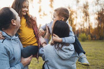 Couple carrying two children spending time together. Family day.