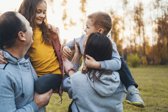 Couple carrying two children spending time together. Family day.