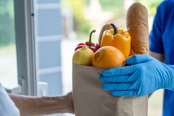 Deliveryman send bags of food to customers in front of the home during the epidemic of Covid-19....