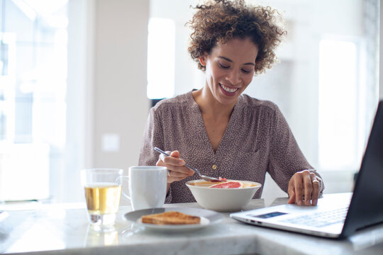 Smiling woman setting table for breakfast