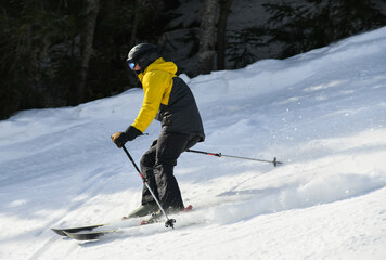 Skier skiing down through fresh powder. Motion photo.