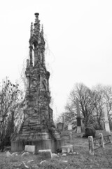 Large memorial overgrown with vines. Cemetery. Black and white.