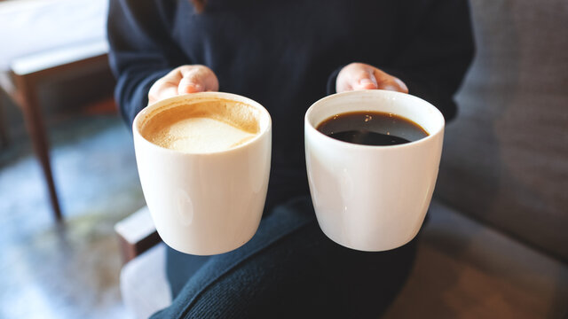 Closeup image of a woman holding and serving two cups of coffee