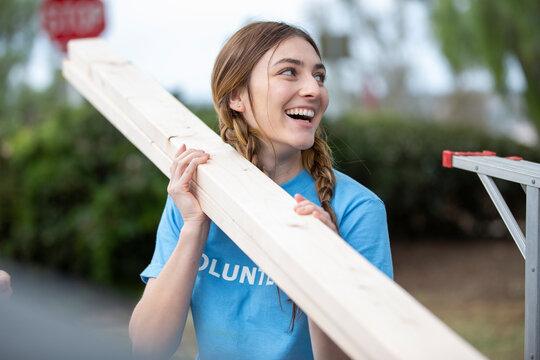 Side View Of Mature Woman With Volunteers Working At Construction Site