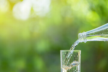Pour the clean water from the water bottle into the glass.