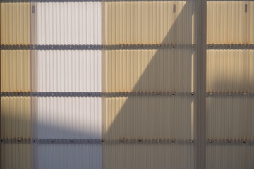 プラスチックの波板の塀に映る影