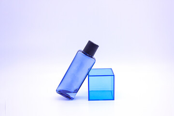 White background, blue cosmetics, plastic container.
