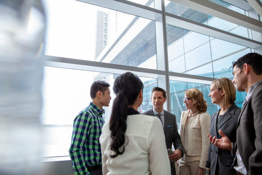 Group of business people talking together in office building