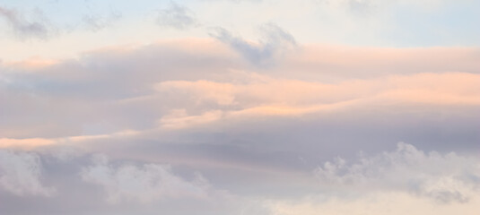 Background of blue sky with white and pink clouds in sunset