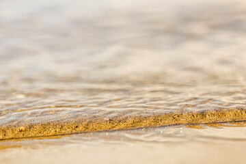 Flowing wave on the sea sandy beach. Summer vacation background