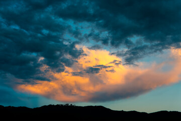 Dramatic sunset in rural Guatemala, silhouettes of mountains and colorful sky in clouds of January 2022.