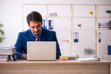 Young male employee sitting at workplace