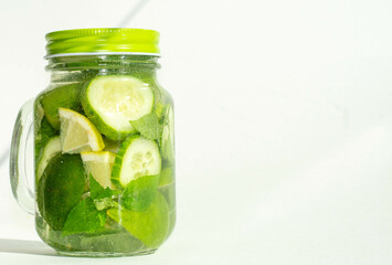 Health care, fitness, healthy nutrition diet concept. Fresh cool lemon cucumber mint infused water, cocktail, detox drink, lemonade in a glass jar.