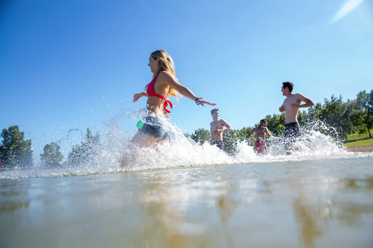 Group Of Friends Running Into Lake