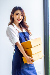 Small business owner looking at company's past online sales, cropped image of woman holding her own box for delivery at online sales office, merchandising concept and modern businessman.