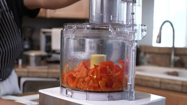 Mincing chopped sweet red bell peppers in the food processor by pulsing the power button - side view slow motion GUMBO SERIES