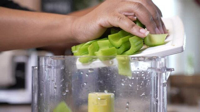 Dumping sliced celery into the food processor to mince in preparation for a gumbo recipe - slow motion GUMBO SERIES