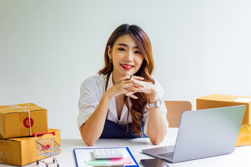 An online business owner checks the name and address of a customer ordering a company product, Cropped photo of a woman checking and writing the name on a parcel for delivery at an online sale office.