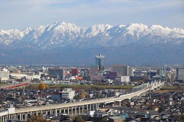 Fototapeta na wymiar 雪化粧した山と市街地の風景