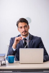 Young male employee sitting at workplace