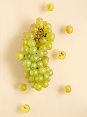 Beautiful grape lie on  yellow pastel background. Nature fruit minimalism.