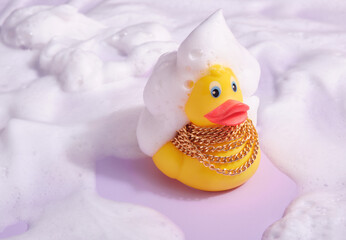 Yellow rubber duck with gold chain and foam on head and around. Positive shower mood.