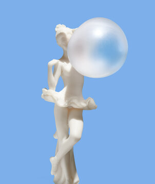 Statuette of ballerina and inflated bubble gum ball. Art, aesthetics, creative mood.