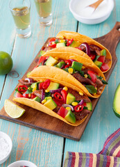 Tacos with pork, avocado, tomatoes, corn and onions. Mexican food.