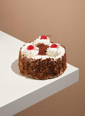 Delicious sponge cake with whipped cream and cherries is waiting to be served on festive table. Happy sweet mood and creative inspiration.