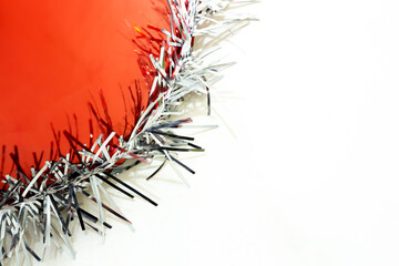Part of new year party hat background photo on white isolated background. The red party hat has bright ornaments on the brim. There is free text space on the right. New year, fun, party concept.