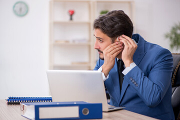 Deaf male employee using hearing aid at workplace