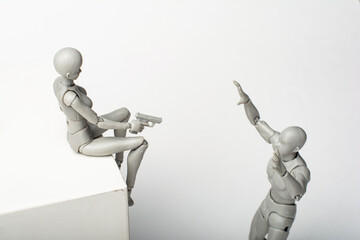 Figurine of a woman aiming a pistol at a male figurine.