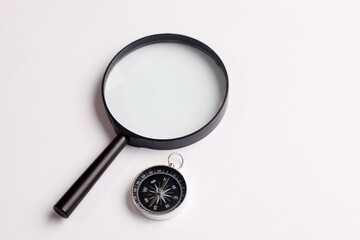 Top view of vintage compass with ruler and magnifying glass on white background