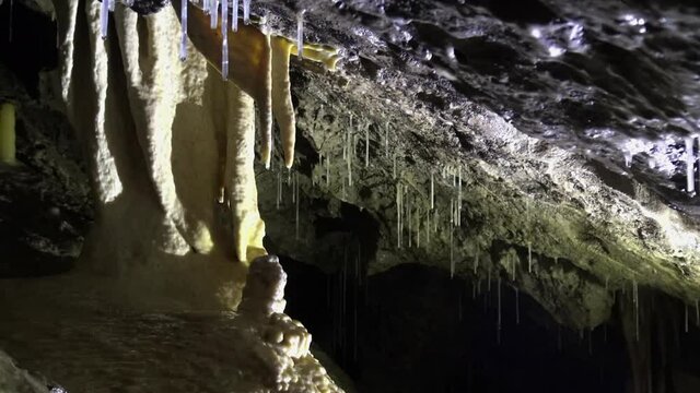 Shifting light in black cave shows different beautiful speleothems