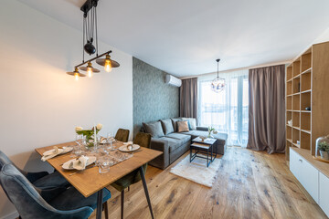 New modern living room with table served. New home. Interior photography. Wooden floor.