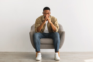 Frustrated African Guy Thinking About Problems Sitting Over Gray Wall