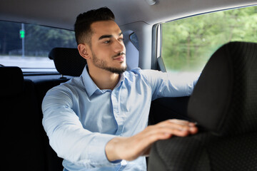 Handsome arab businessman going to office by taxi