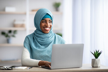 Remote Career. Happy Black Muslim Woman Sitting At Desk With Laptop