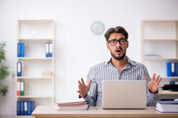 Young male employee sitting in the office
