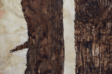 Pieces of Old worn cloth on textured wood surface.