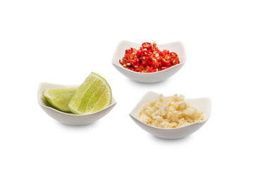 Chili, minced garlic and sliced lemon in a small ceramic bowl isolated on white background. Clipping path.