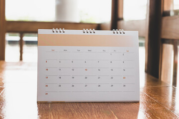 White desk calendar on dark wooden table, planning concept.	