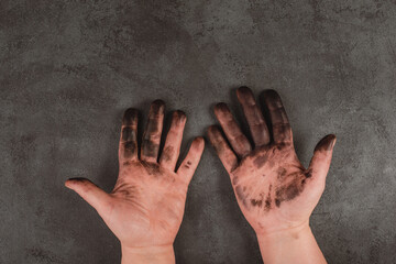 Dirty hands covered with color, fuel oil, mechanic worker, repair job, dark textured background
