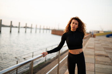 Young woman doing stretching exercise after running outdoors. Beautiful young woman training outside..