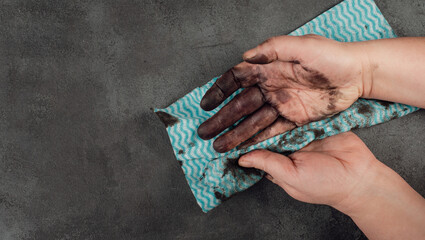 Cleaning dirty hands with a piece of clothes, fuel oil, mechanic worker, repair service, dark background