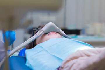 Dentistry. Little girl getting Inhalation Sedation while teeth treatment at dental clinic. Teeth treatment child.