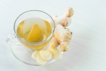 Closeup Fresh ginger with sliced and hot ginger glass on white white table, herb and medical for health concept, copy space