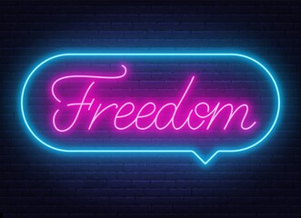 Freedom neon sign in the speech bubble on brick wall background.