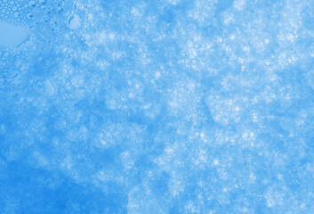 Soap foam macro background.Hygiene, health and cleanliness concept.White soap foam with bubbles on a light blue background. Cleaning, tidiness and cleanliness concept. Bath foam.